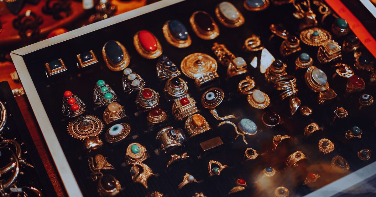 A display case filled with an assortment of ornate vintage gemstone rings