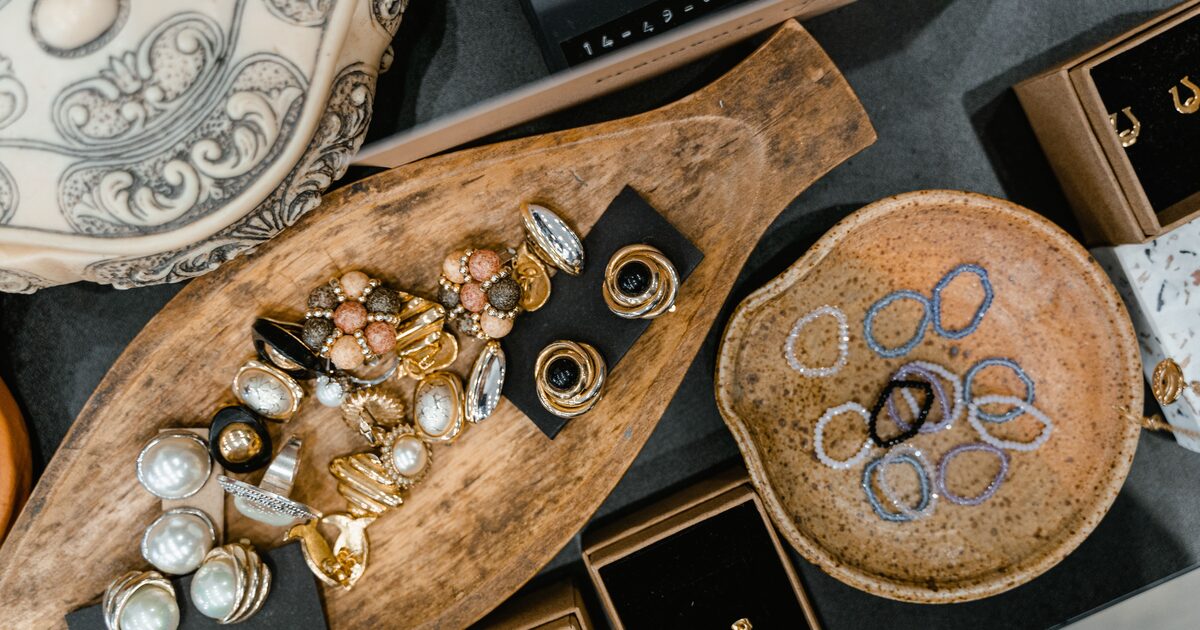 Vintage jewellery and gemstones arranged on a wooden tray